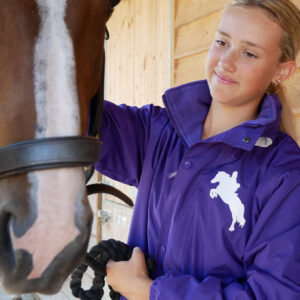 Young female rider with horse wearing a Storm Dri riding jacket from luvponies.com These jackets receive rave reviews for their warmth and quality.